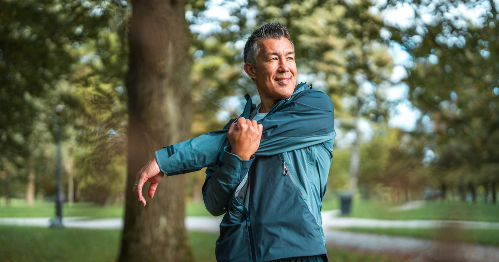 Smiling man stretching in a public park 