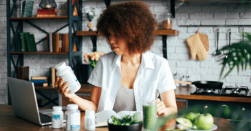 Executive reviewing supplement labels with a laptop
