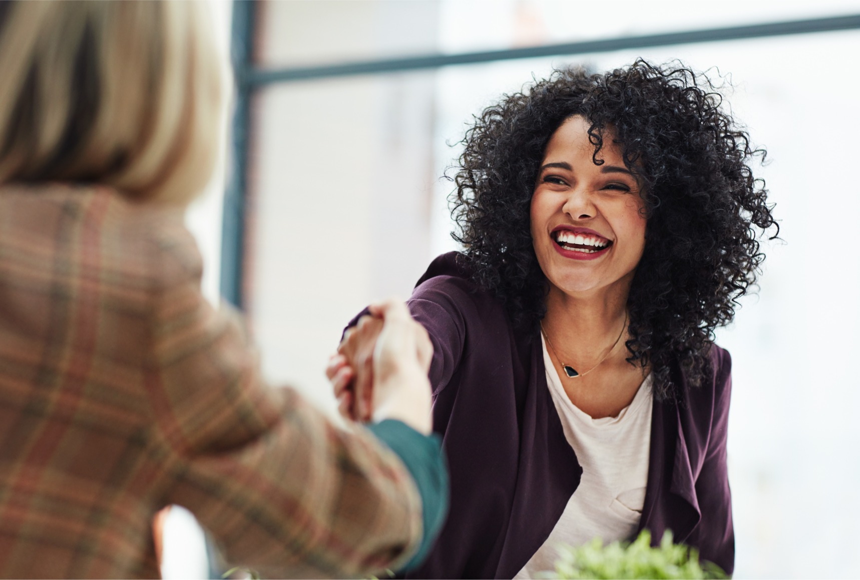 A company photo showcasing a cultural change within an office as a group of people shake hands.
